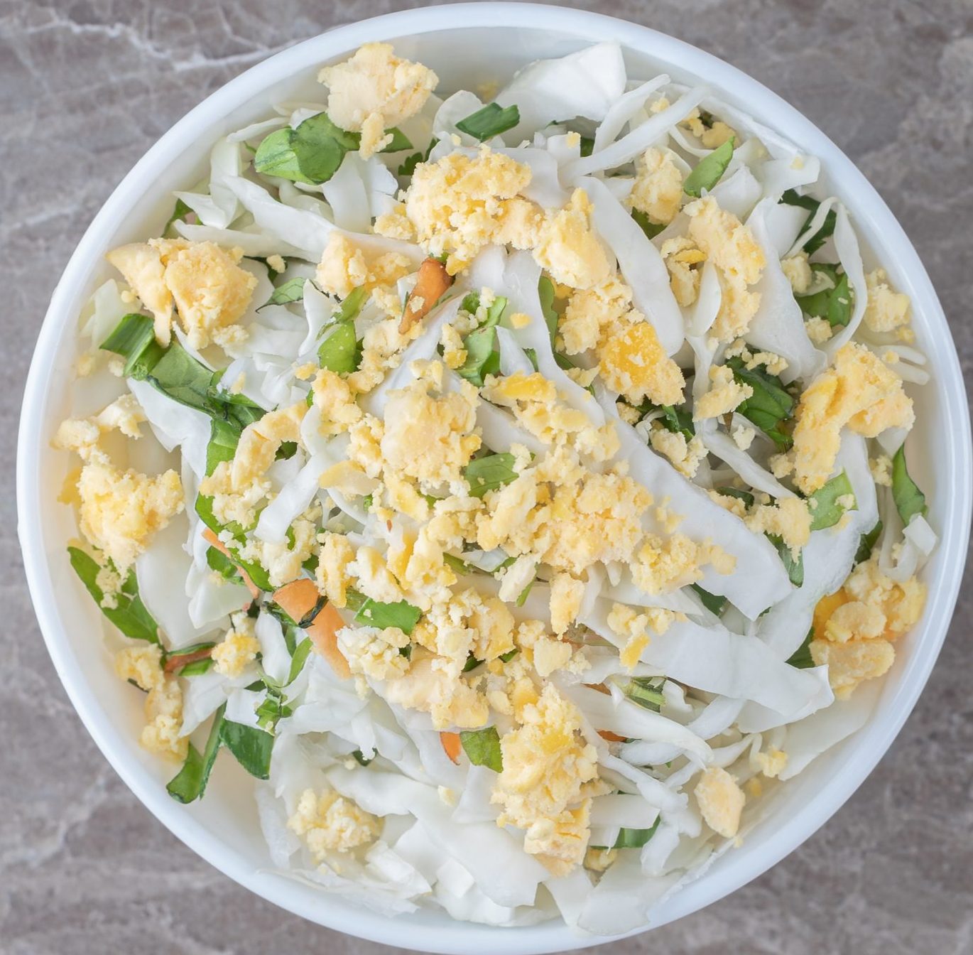 fried eggs and fresh salad in white bowl